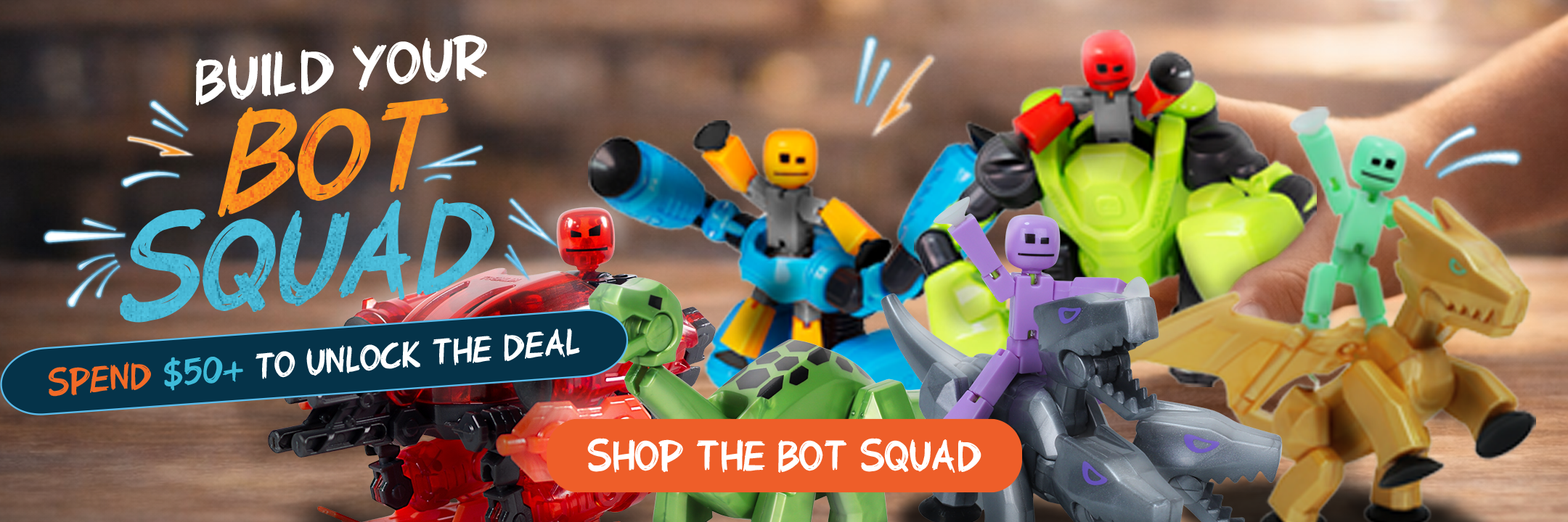 Playful display of colorful robot toys and action figures arranged as a collectible bot squad, promoting building, imaginative play and a shop promotion to unlock deals with purchases over $50.