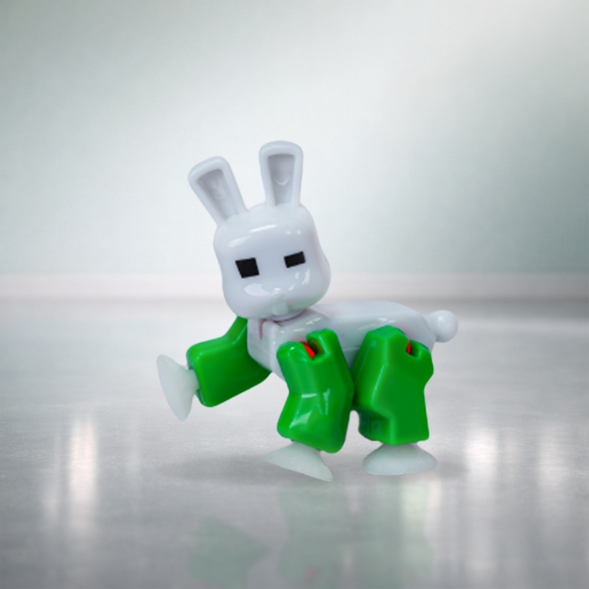 White and green BunnyBot figure posed in playful action stance with suction cup feet
